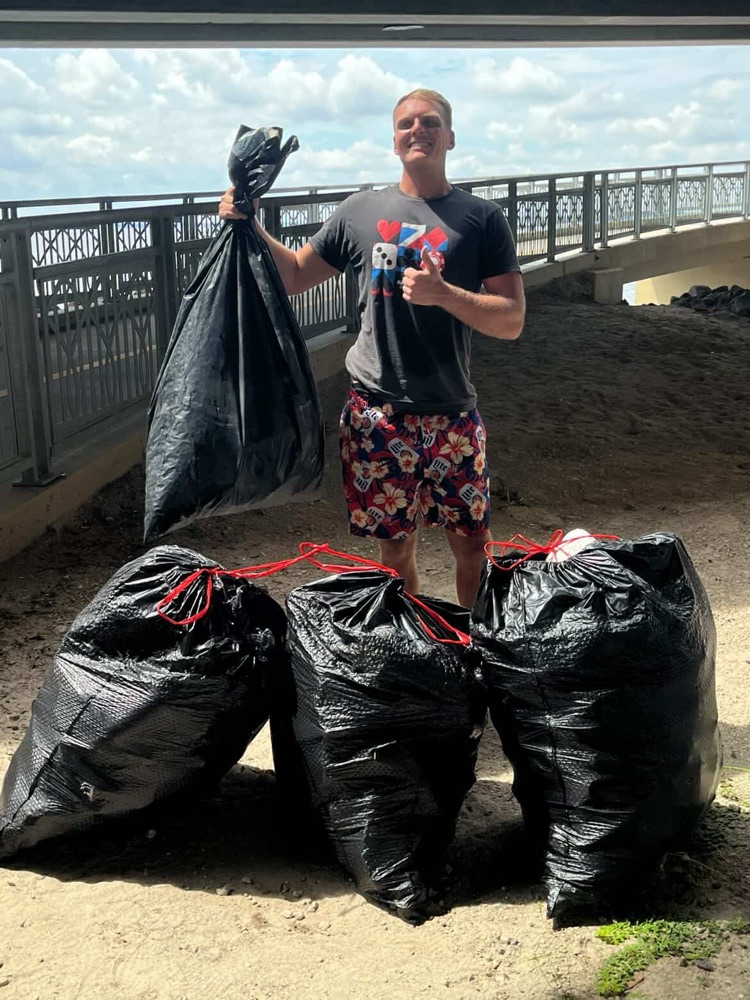 A 904 Walk Club volunteer holding bags of trash collected on a community cleanup